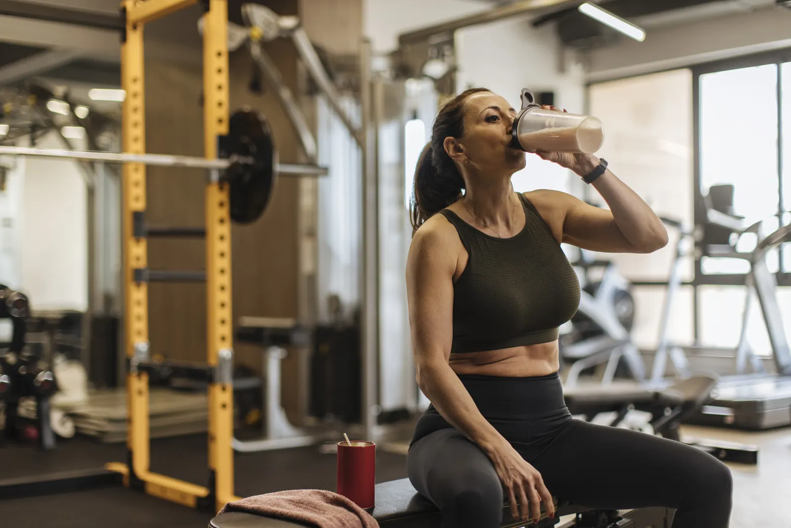 Woman drinking a protein shake at the gym
