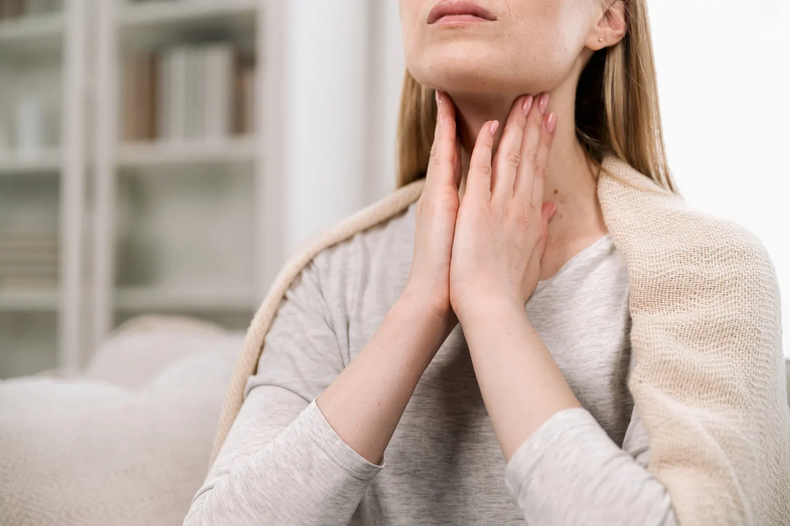 Woman gently touching the front of her neck