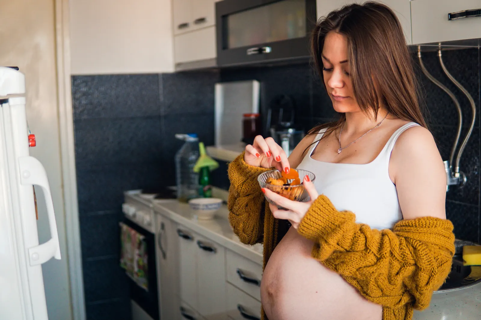 Woman eating a snack in her kitchen